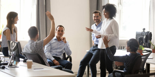 Diverse team in coworking space voting some colleagues agree raises hands. Positive black leader woman with creative group of businesspeople discussing sharing ideas together in office at meeting